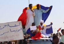 Protesters wave Chadian flags during an anti-France demonstration in N'djamena on 6 December 2024.