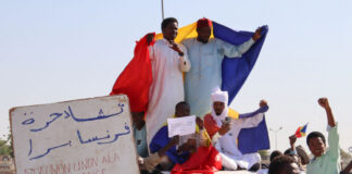 Protesters wave Chadian flags during an anti-France demonstration in N'djamena on 6 December 2024.