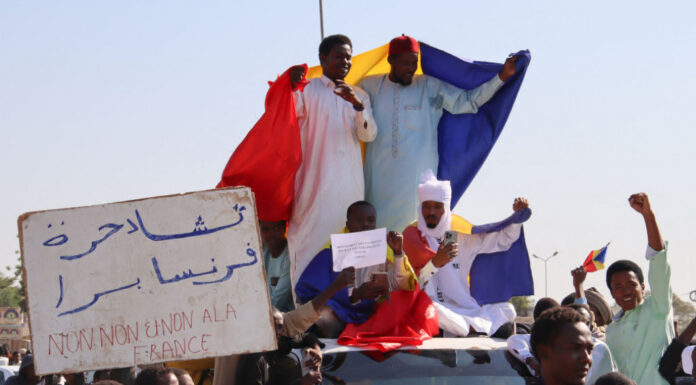 Protesters wave Chadian flags during an anti-France demonstration in N'djamena on 6 December 2024.